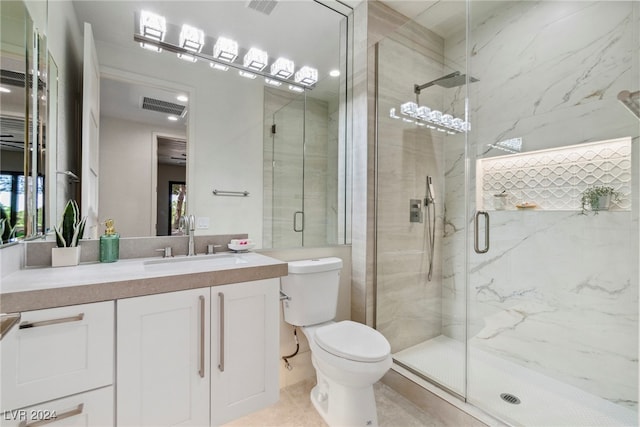 bathroom with tile patterned flooring, vanity, toilet, and walk in shower