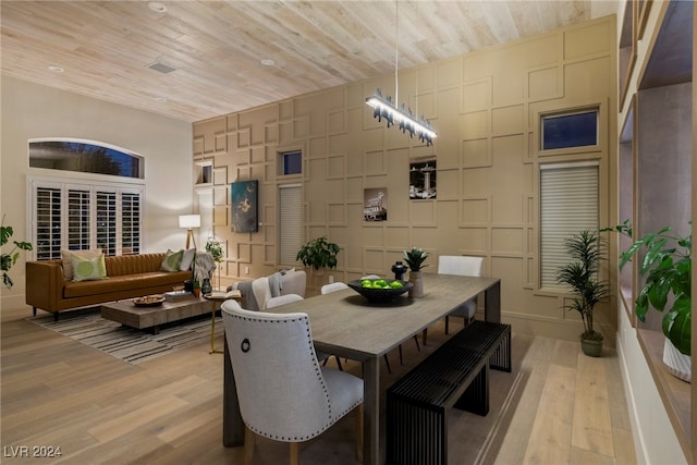 dining room with light hardwood / wood-style floors and wooden ceiling