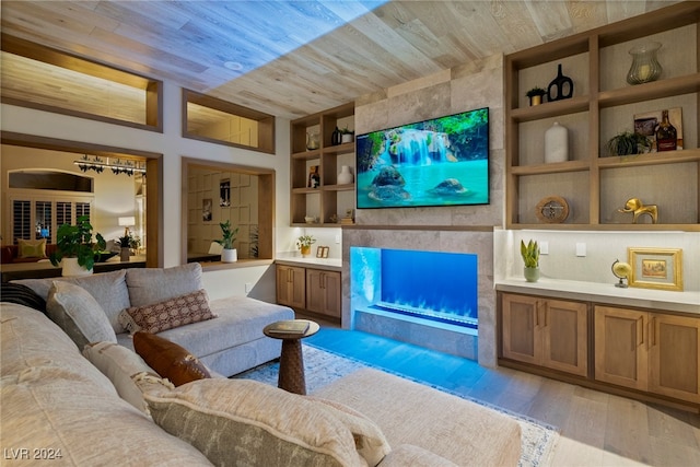 living room featuring built in shelves, light hardwood / wood-style floors, and wood ceiling