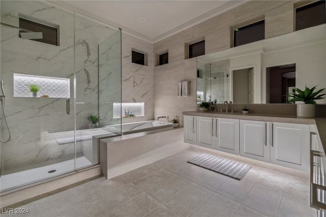 bathroom with tile patterned flooring, vanity, separate shower and tub, and tile walls