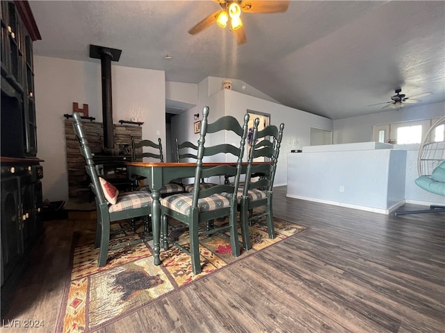 dining space with ceiling fan, dark hardwood / wood-style flooring, and vaulted ceiling