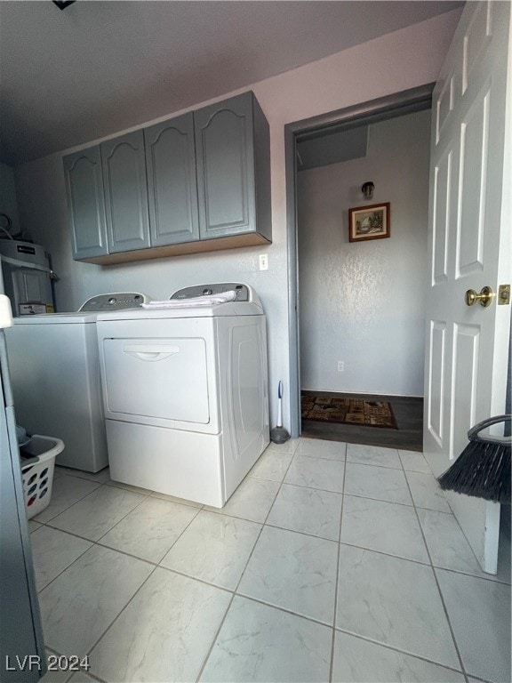 laundry area with cabinets and washing machine and clothes dryer