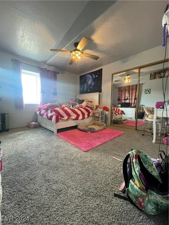 carpeted bedroom with ceiling fan, a closet, and a textured ceiling