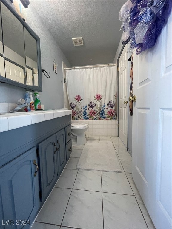 bathroom featuring vanity, a textured ceiling, and toilet