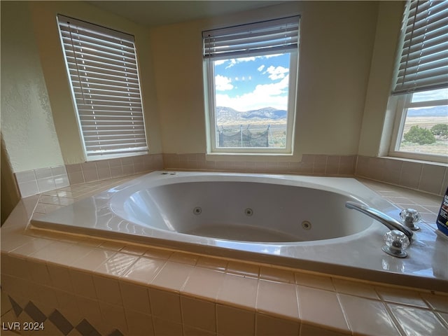 bathroom featuring a mountain view and tiled bath