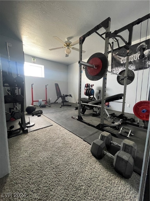 exercise room with ceiling fan and a textured ceiling