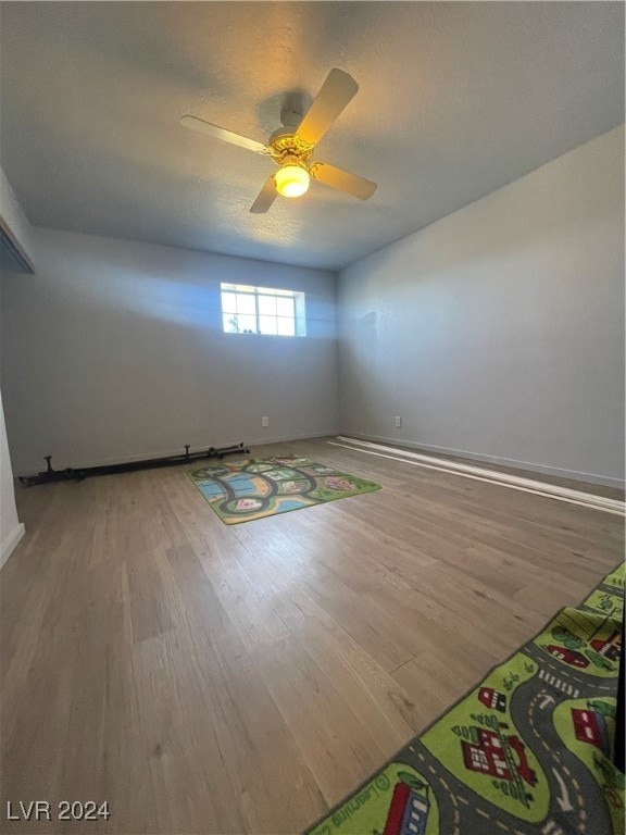 unfurnished room featuring ceiling fan, wood-type flooring, and a textured ceiling