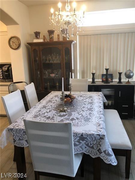 dining area with hardwood / wood-style floors and a notable chandelier