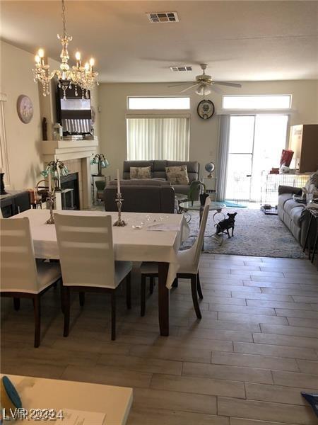 dining room featuring hardwood / wood-style flooring and ceiling fan with notable chandelier