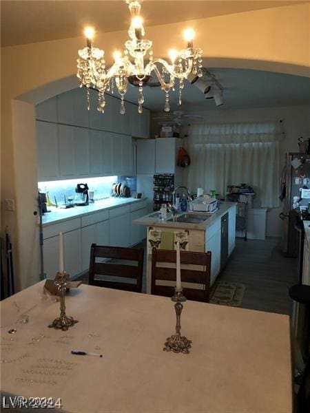 kitchen featuring a center island with sink, decorative light fixtures, a notable chandelier, and sink