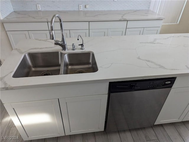 kitchen with white cabinetry, dishwasher, hardwood / wood-style floors, and sink