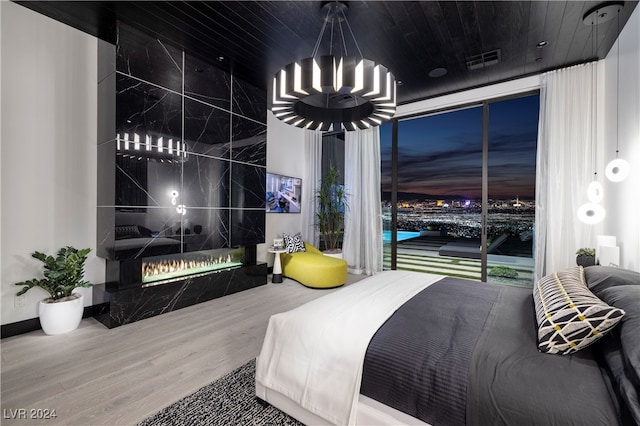 bedroom featuring wood-type flooring, a fireplace, and wood ceiling