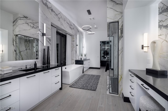 bathroom with hardwood / wood-style floors, vanity, and independent shower and bath