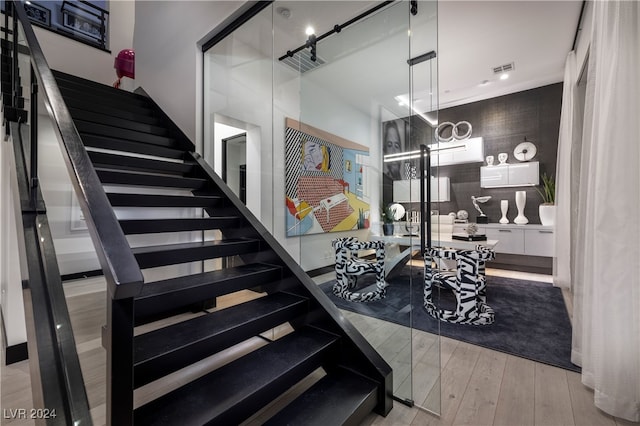 staircase with hardwood / wood-style floors