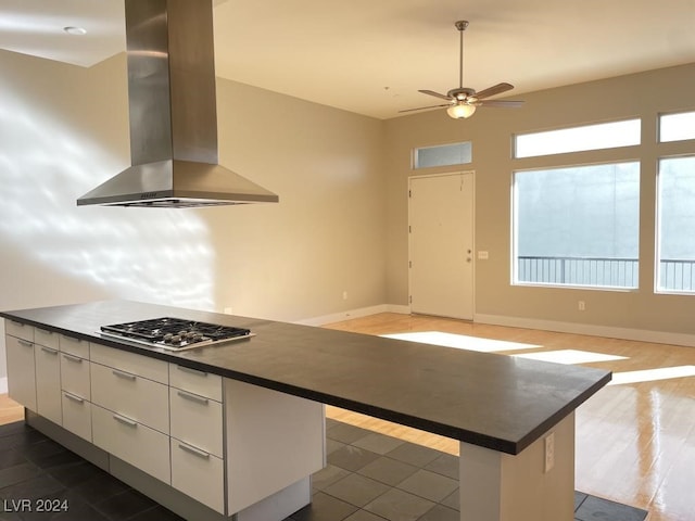 kitchen with a center island, a healthy amount of sunlight, white cabinetry, and extractor fan