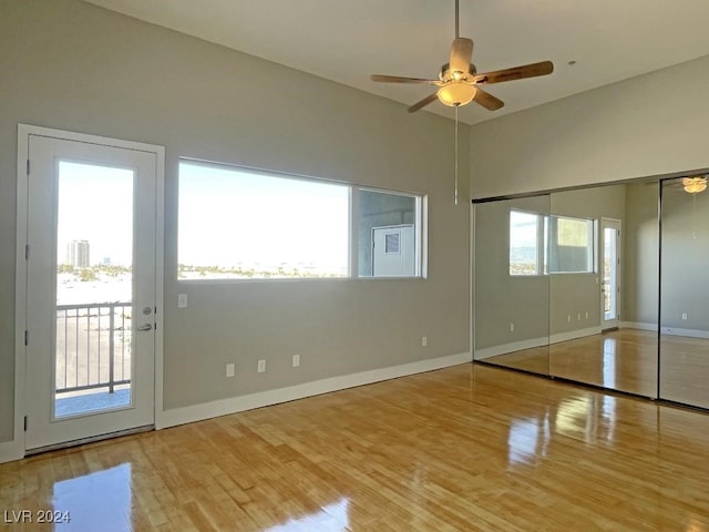 unfurnished bedroom featuring access to exterior, light hardwood / wood-style flooring, a closet, and ceiling fan