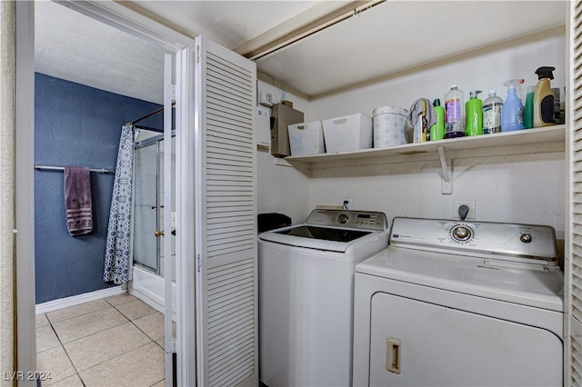 laundry room featuring washing machine and clothes dryer and light tile patterned flooring