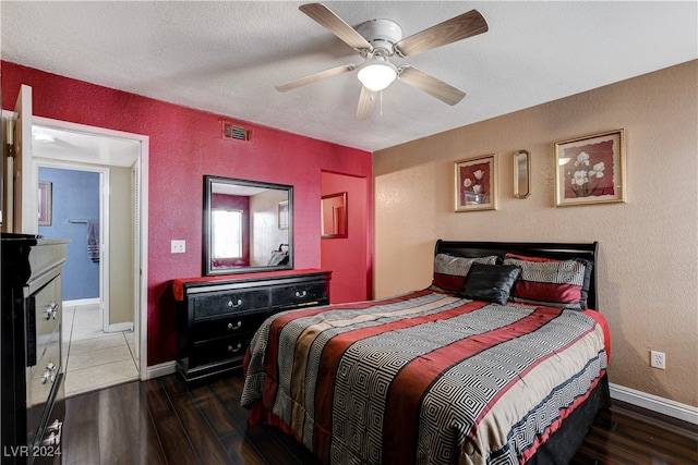 bedroom featuring dark hardwood / wood-style floors, ceiling fan, and a textured ceiling