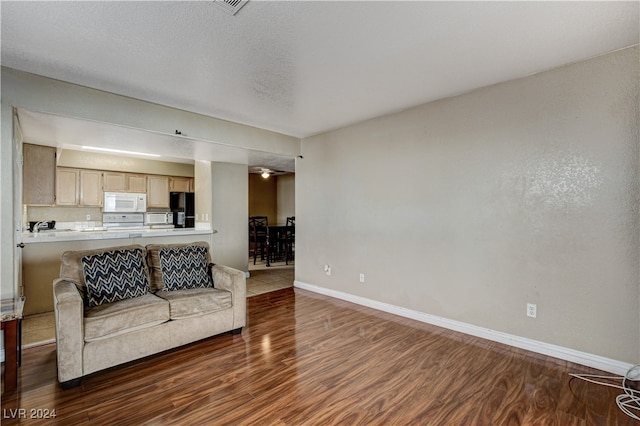 living room featuring a textured ceiling and dark wood-type flooring