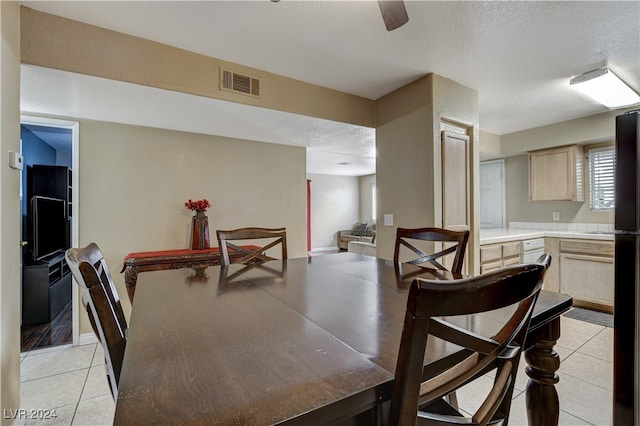 tiled dining area with a textured ceiling