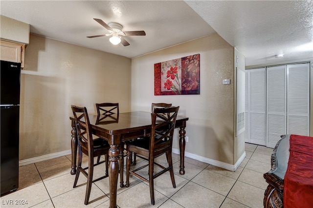 dining area with ceiling fan, light tile patterned floors, and a textured ceiling