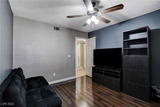 living room with a textured ceiling, dark hardwood / wood-style floors, and ceiling fan