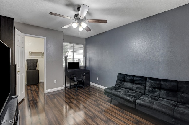 living room with ceiling fan, dark hardwood / wood-style flooring, and a textured ceiling