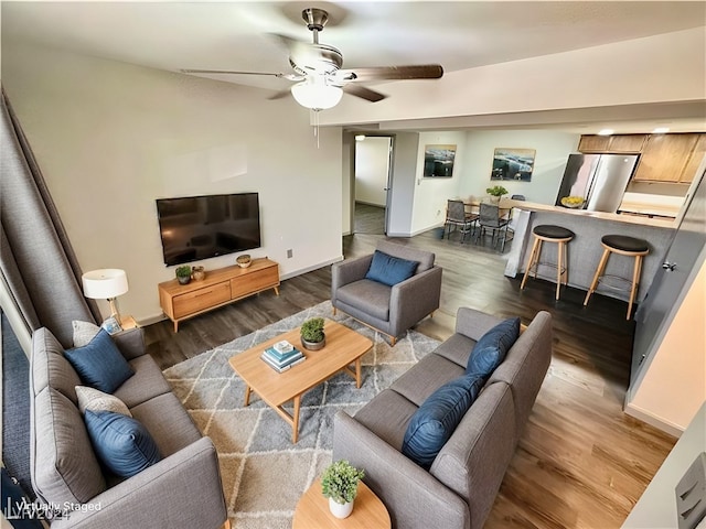 living room featuring ceiling fan and dark wood-type flooring