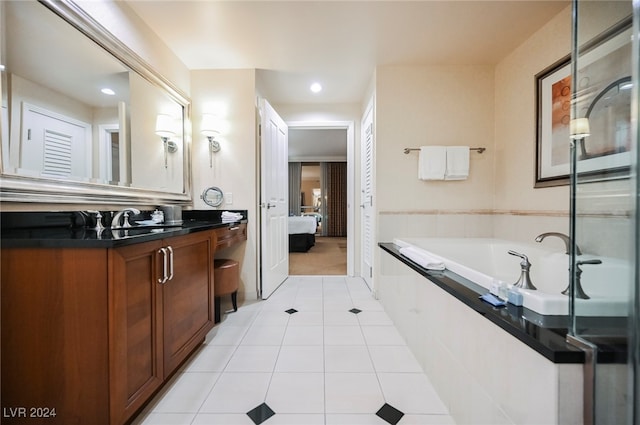 bathroom featuring tile patterned flooring, vanity, and tiled tub