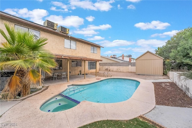 view of swimming pool with an in ground hot tub, central AC, a storage unit, and a patio area