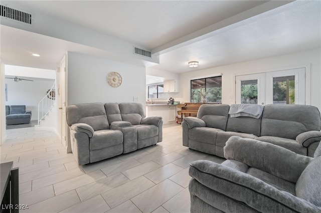 living room with ceiling fan, french doors, and a healthy amount of sunlight