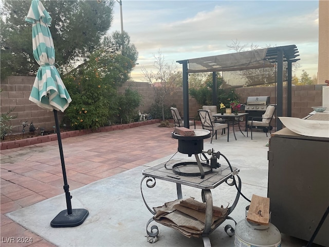 patio terrace at dusk featuring a pergola and area for grilling