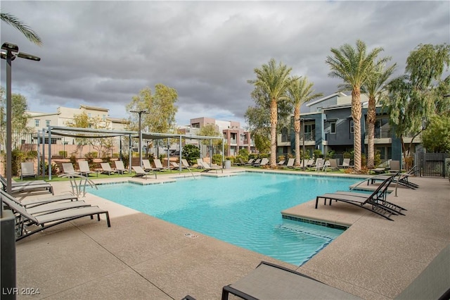 pool with a residential view, a patio, and fence