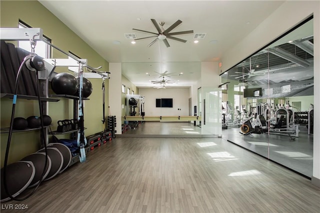 gym featuring wood finished floors, visible vents, and a ceiling fan