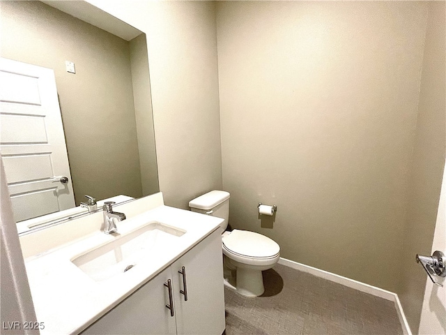 bathroom with toilet, baseboards, and vanity