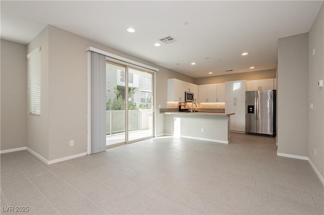 kitchen featuring a kitchen breakfast bar, sink, white cabinetry, kitchen peninsula, and stainless steel appliances