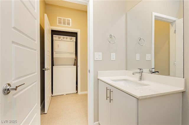 bathroom with vanity and stacked washer and clothes dryer