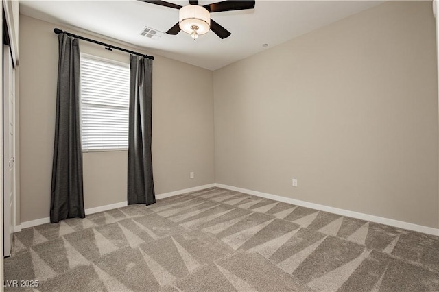 empty room featuring light colored carpet, visible vents, ceiling fan, and baseboards