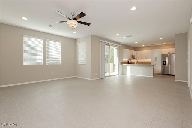 unfurnished living room with ceiling fan