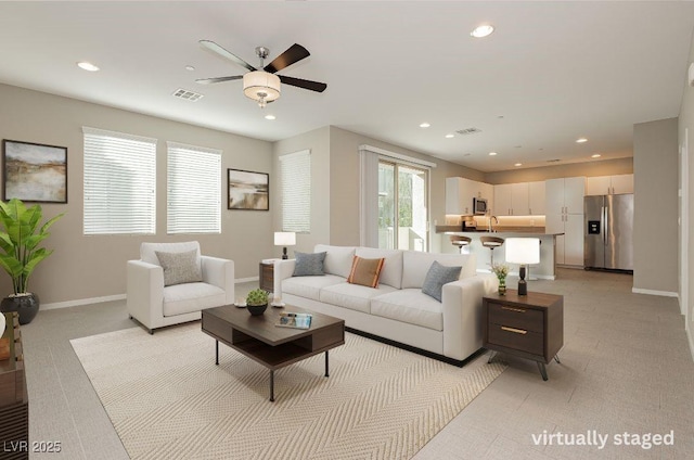 living room featuring baseboards, visible vents, and recessed lighting