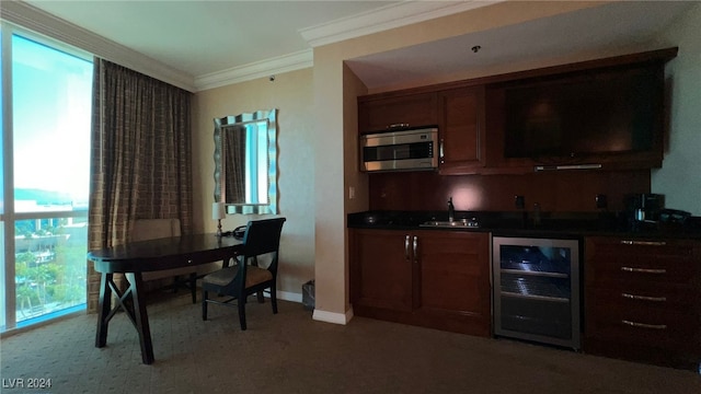 kitchen with wine cooler, crown molding, and sink