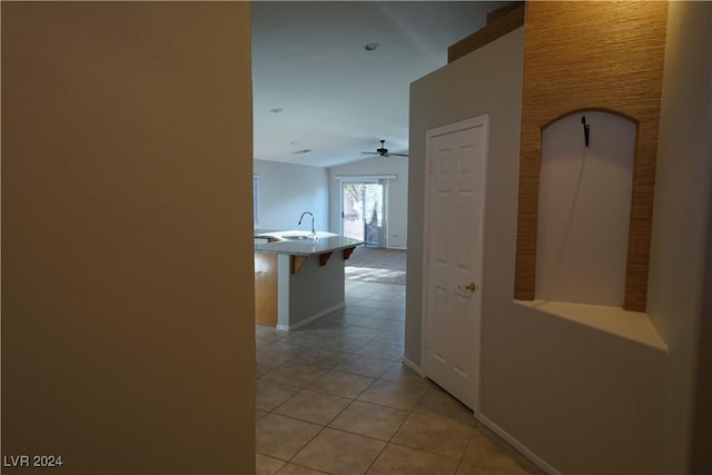 corridor with light tile patterned flooring and lofted ceiling