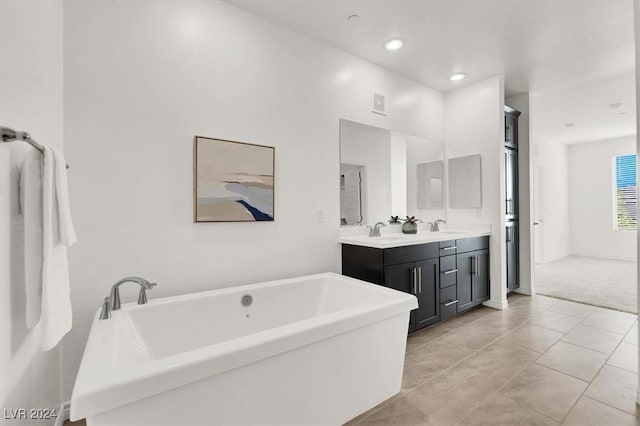 bathroom with a tub to relax in, tile patterned floors, and vanity