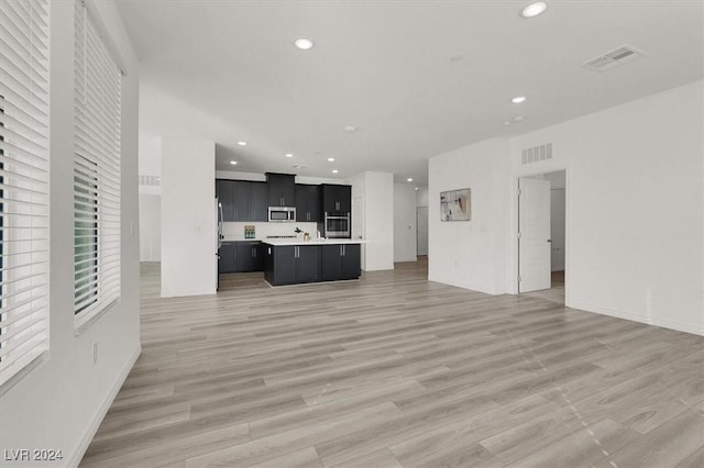 interior space featuring light hardwood / wood-style flooring, a kitchen island, and stainless steel appliances