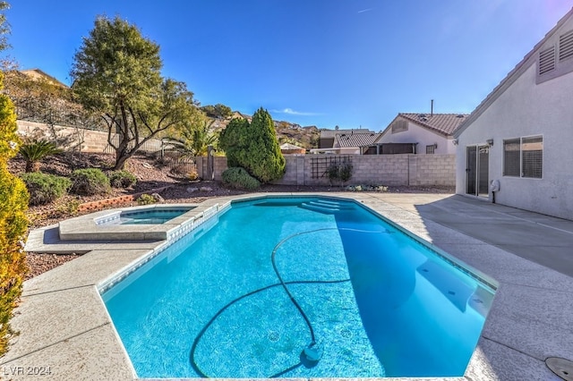 view of swimming pool with a patio area and an in ground hot tub