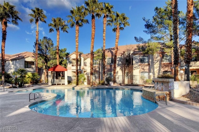 pool with a residential view, fence, and a patio