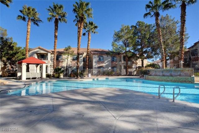 pool with a patio and fence