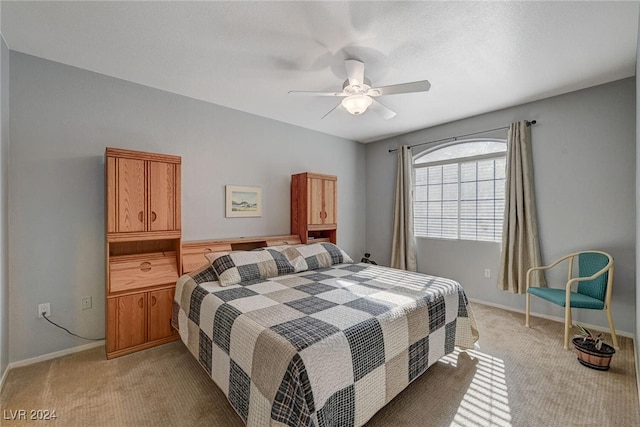 bedroom with light colored carpet, ceiling fan, and baseboards