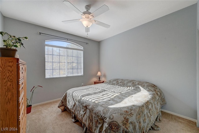 bedroom with baseboards, a ceiling fan, and light colored carpet