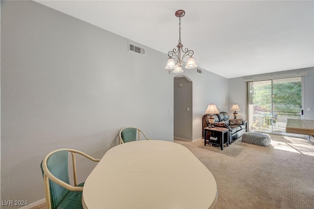 dining area with arched walkways, carpet floors, visible vents, and a notable chandelier